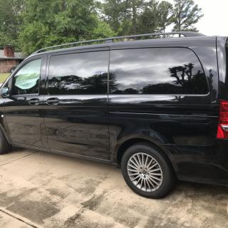 A black van parked on a driveway.