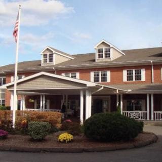 A well-maintained residential building with a covered entrance and landscaped garden.