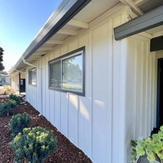 A modern white house exterior with clean landscaping and a prominent window.