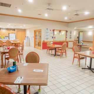 An empty restaurant dining area with neatly arranged tables and chairs.
