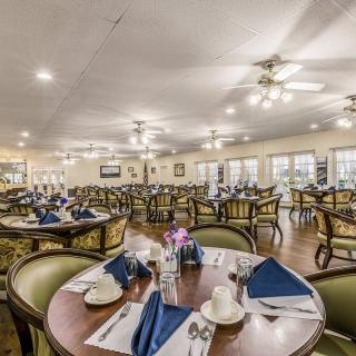 Spacious dining area with neatly arranged tables and elegant place settings.