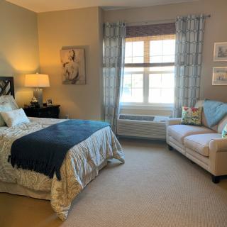 A cozy bedroom with a bed, a sofa, and decorative elements.