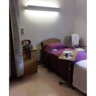 A hospital room with a bed and medical equipment.