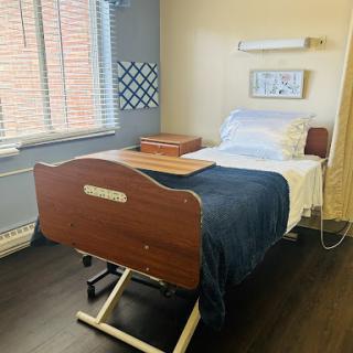 A patient room featuring a hospital bed, equipped with essentials for care.