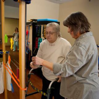 An elderly person receiving assistance during a physical therapy session.