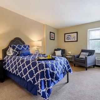 A cozy bedroom with a stylish bed and armchairs.