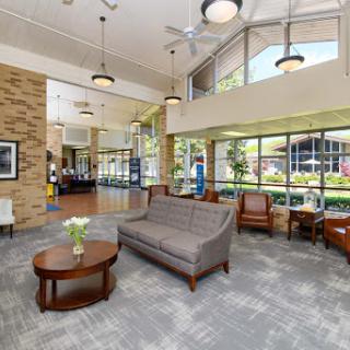 A spacious and inviting lobby featuring comfortable seating, large windows for natural light, and a modern aesthetic.