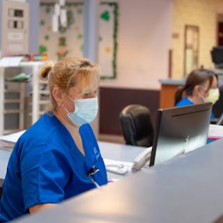 Healthcare professionals working diligently at their stations in a hospital setting.