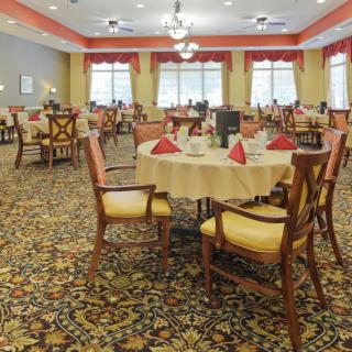 A spacious and elegantly decorated dining room with neatly arranged tables and chairs.