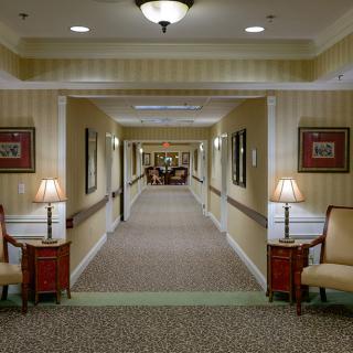 A well-lit hotel hallway with elegant furniture and decor.