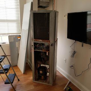An unfinished room with a partially installed appliance next to a television.