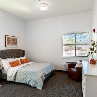 A cozy bedroom with a comfortable bed, a window view, and simple decor.