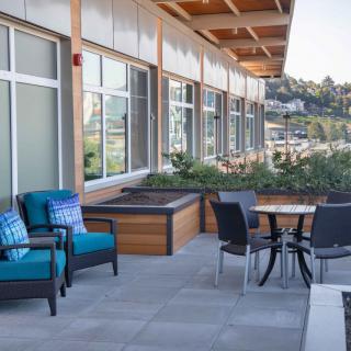 A modern outdoor patio with comfortable seating and a view of the city.