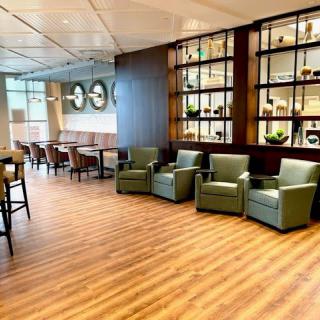 A modern lounge area with comfortable armchairs and decorative shelving.