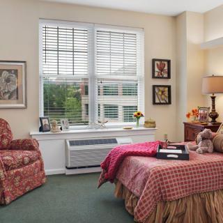 A cozy bedroom with a neatly made bed and window view.
