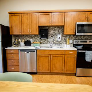 A modern kitchen featuring wooden cabinets, stainless steel appliances, and a stylish backsplash.