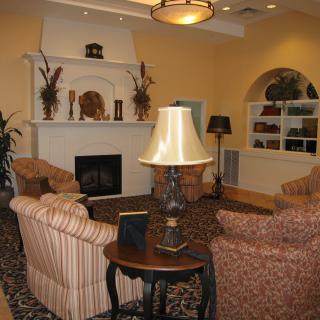 A cozy living room with a central fireplace, surrounded by comfortable sofas and elegant decor.