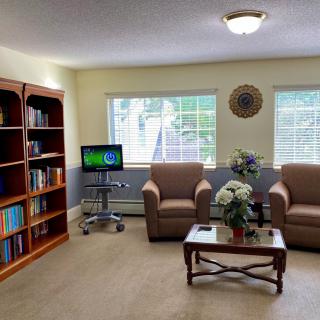 A cozy living room with bookshelves and comfortable seating.