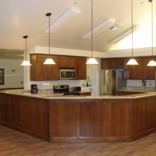 A modern kitchen with wooden cabinets, an island, and stainless steel appliances.