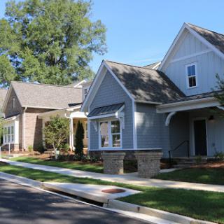 A picturesque view of a suburban neighborhood featuring modern houses under a clear blue sky.