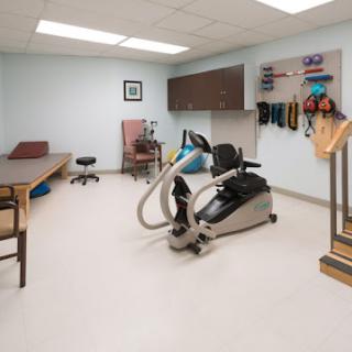 A well-equipped physical therapy room featuring exercise equipment and rehabilitation tools.