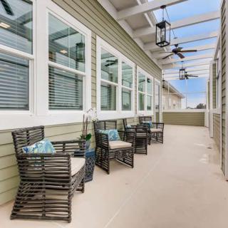 A modern outdoor patio with comfortable seating and ceiling fans.