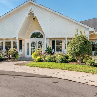A charming residential house with a well-maintained garden and driveway.