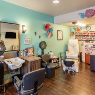 A colorful and cozy salon interior featuring styling chairs, mirrors, and decorative elements.