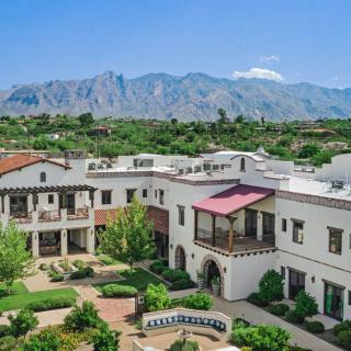 A scenic view of a large residential building complex with mountains in the background.