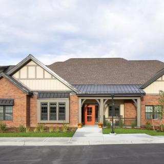 A modern brick residential house with a well-maintained front yard and driveway.