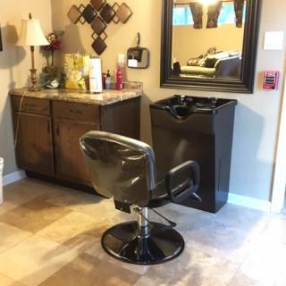 A cozy hair salon setup with a styling chair, mirror, and vanity.