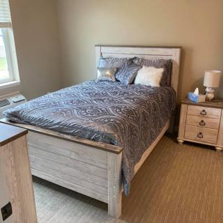 A cozy bedroom with a neatly made bed and bedside table.