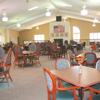 An interior view of a spacious dining hall with multiple tables and chairs arranged for seating.