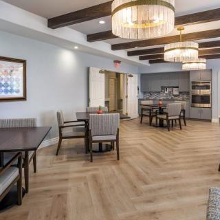 A modern dining area with elegant lighting and wooden flooring.
