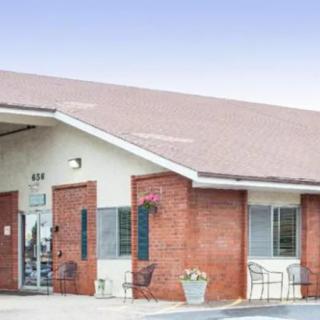 A brick commercial building with a front entrance and seating area.