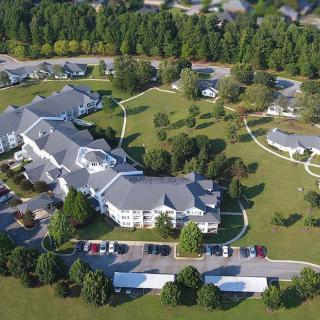 Aerial view of a residential complex surrounded by green spaces and trees.