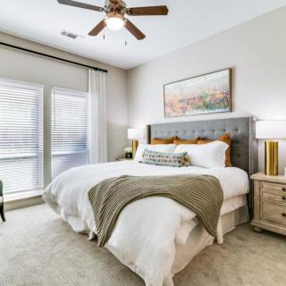 A modern bedroom with a comfortable bed, stylish decor, and ample natural light.