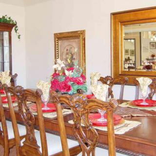 A dining room with an elegantly set table, featuring a floral centerpiece and decorative elements.