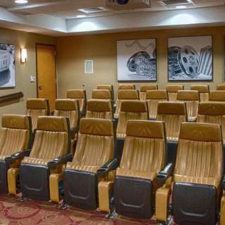 An empty movie theater with rows of comfortable seats.