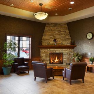 A cozy lobby features a stone fireplace with comfortable seating and warm ambient lighting.