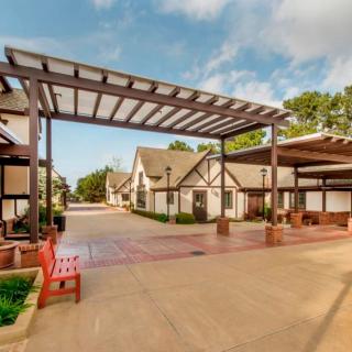 A view of a series of quaint buildings with a covered walkway in an outdoor setting.