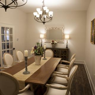 Elegant dining room with a wooden table, classic chairs, and a decorative chandelier.