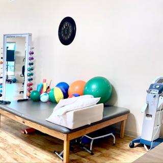 A well-equipped physical therapy space featuring various exercise tools and fitness balls.