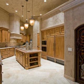 A luxurious kitchen with wooden cabinetry, a large island, and modern appliances.