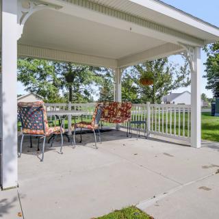 A cozy outdoor patio area with a gazebo covering, featuring a table and chairs for seating.