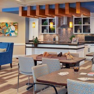 A modern kitchen and dining area with stylish seating and vibrant artwork.