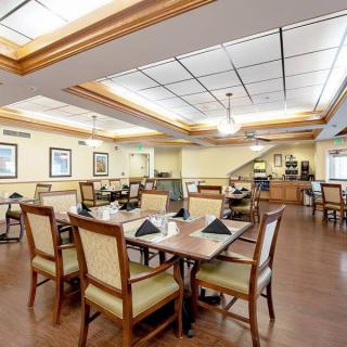 An elegant dining room with neatly arranged tables and chairs, featuring warm lighting and tasteful decor.