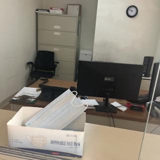 A view of an office workspace with a desk, computer, and filing cabinet.