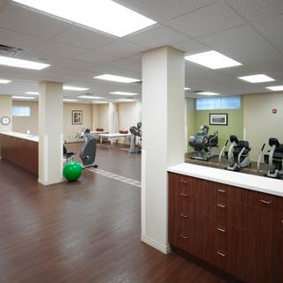 A spacious and modern rehabilitation center equipped with fitness equipment for physical therapy and exercise.