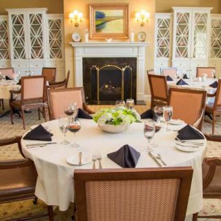 An elegantly set dining table in a sophisticated restaurant with a cozy fireplace.